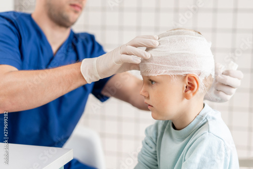 Doctor bandaged a boy head with trauma in his head and elastic bandaged around his head