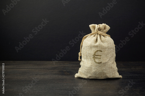 A full bag of dollars on a dark table