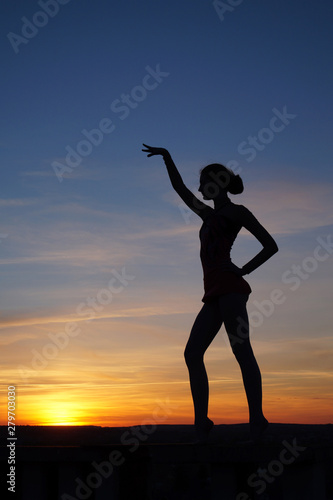 dancer in the dance does the splits in the air against the sunset. © Oleksandr