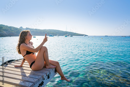 Fototapeta Naklejka Na Ścianę i Meble -  Ibiza girl taking smartphone photos