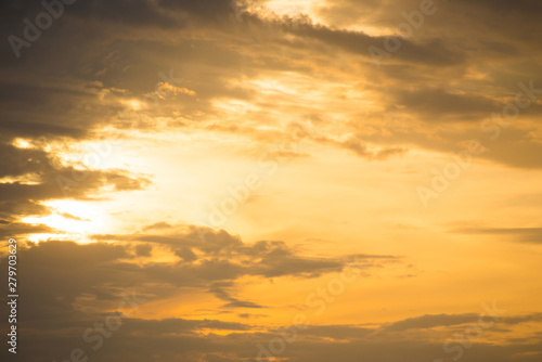 Sunset orange sky with sun and clouds in beige color