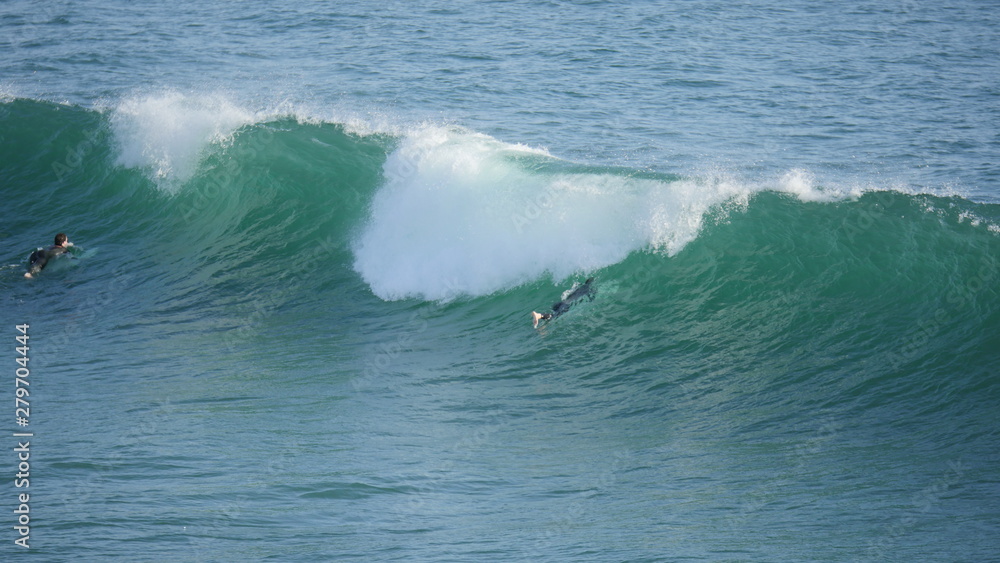 Obraz premium Beach with waves crashing at the ocean with surfer shot in high resolution 4k resolution