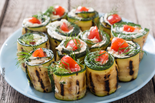 Zucchini rolls with cream cheese , tomatoes and dill