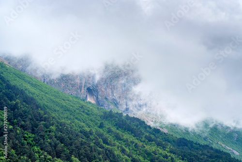 Scenic view of foggy mountains. Clouds and green mountain forest view