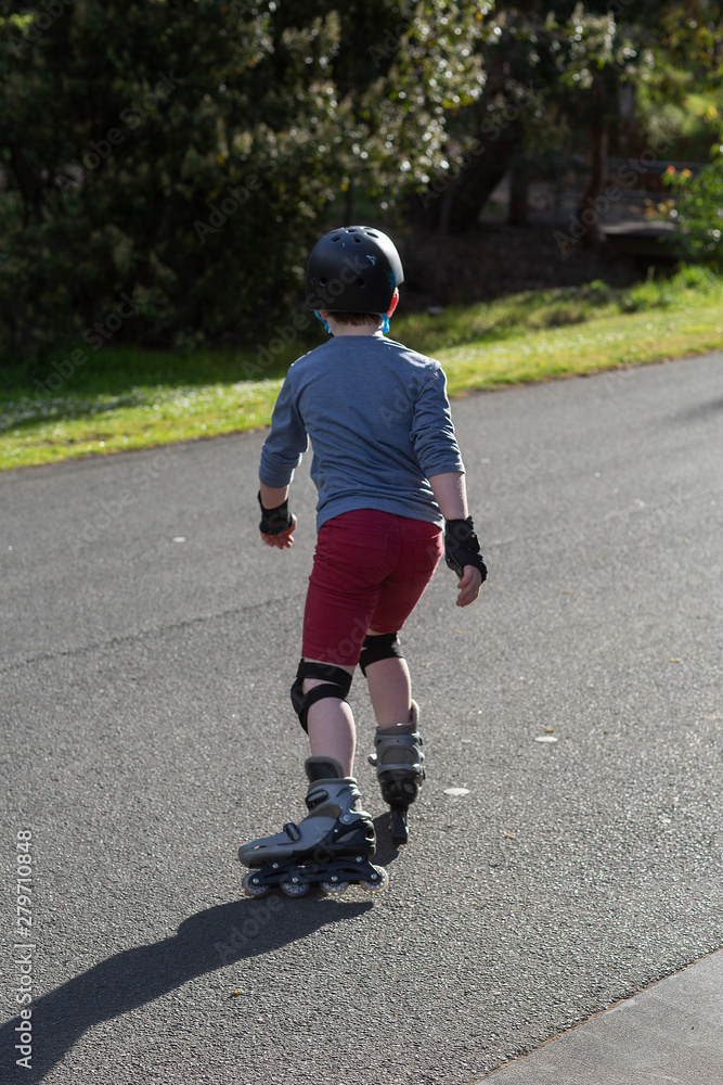 Young boy rollerblading near his home