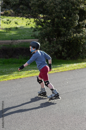 Young boy rollerblading near his home