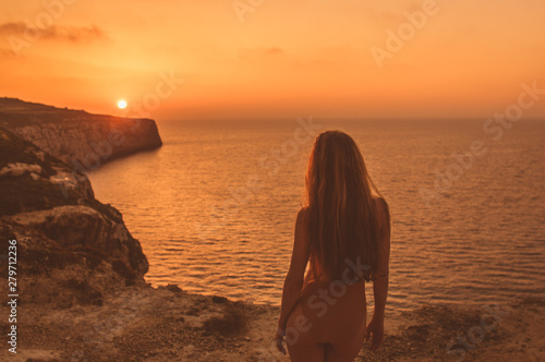 Young woman  staying on mountain on shore in body in sunset © el_caro
