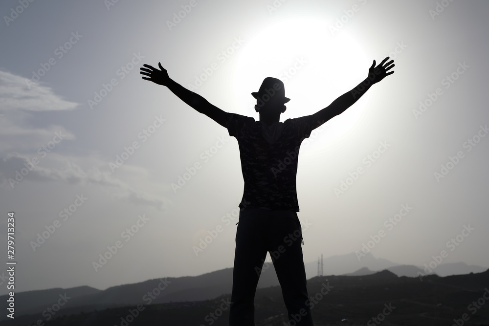 Freedom and travel A man raises his hands with a mountain background Freedom and travel A man raises his hands with a mountain background
