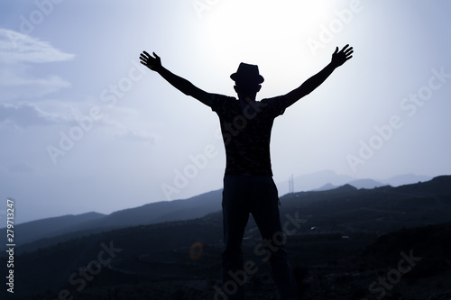 Freedom and travel A man raises his hands with a mountain background
