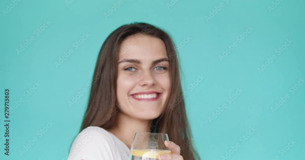 Smiling girl drinks cold water with lemon. cooling drink. Smiling girl drinks cold water with lemon. cooling drink.