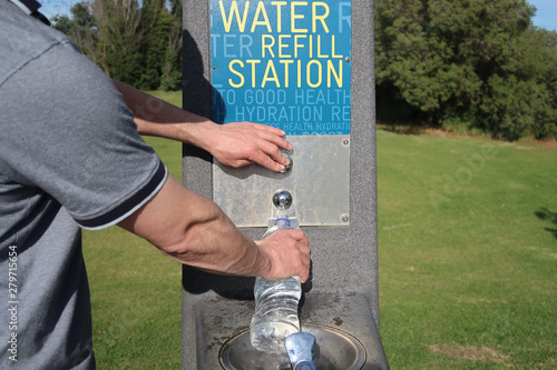 Man filling water bottle at water refill station