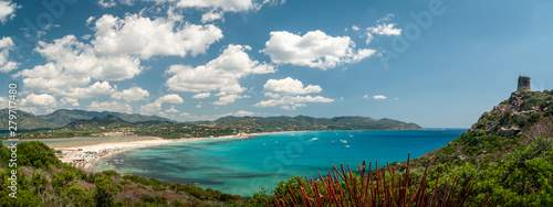 Sardinia, Villasimius. Panoramic view of the Porto Giunco beach with turquoise sea water. On the promontory of Capo Carbonara, the famous Spanish sighting tower and the Notteri pond in the background