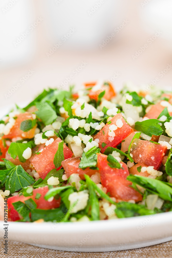 Fresh vegan Tabbouleh salad made of tomato, parsley, onion and couscous on plate (Selective Focus, Focus in the middle of the image) Fresh vegan Tabbouleh salad made of tomato, parsley, onion and couscous on plate (Selective Focus, Focus in the middle of the image)