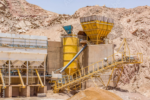 old iron tanks and production line of digging factory industrial object in Middle East desert sand and rocky natural environment 
