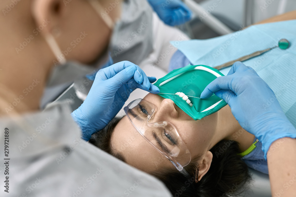 Fototapeta premium Pretty woman's teeth cleaning in dental clinic
