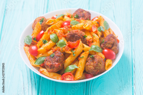 Italian penne pasta with meatballs and tomatoes