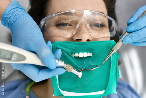 Obraz na plátně Pretty woman's teeth treatment in dental clinic