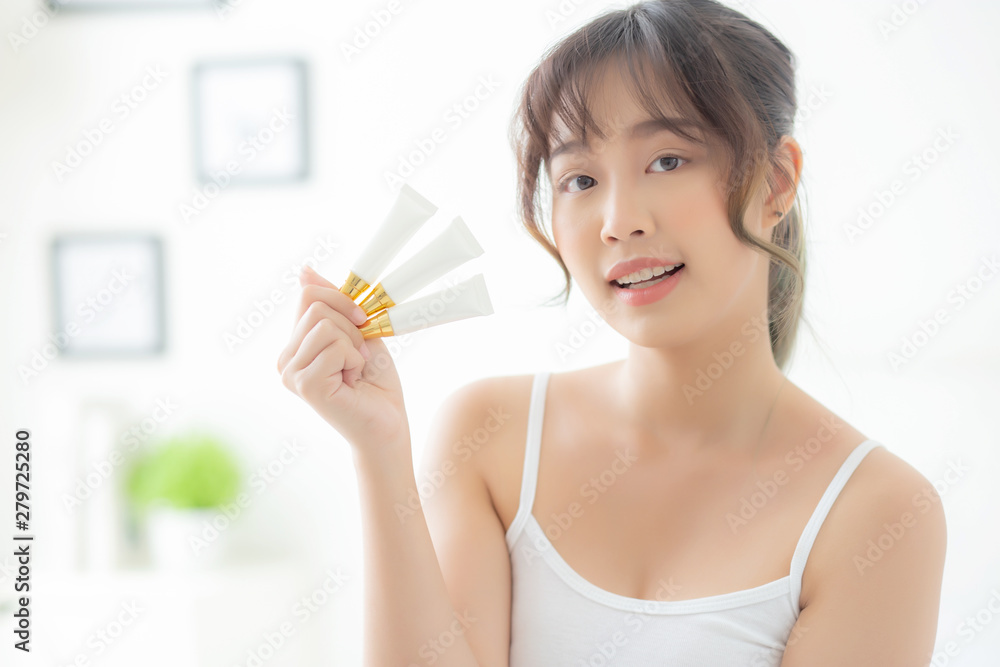 Beautiful portrait young asian woman holding and presenting cream or lotion product, beauty asia girl show cosmetic makeup and moisturizing for skin care, healthy care and wellness concept. Beautiful portrait young asian woman holding and presenting cream or lotion product, beauty asia girl show cosmetic makeup and moisturizing for skin care, healthy care and wellness concept.