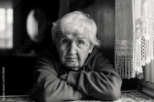Portrait of a lonely sad old woman. Black and white photo.