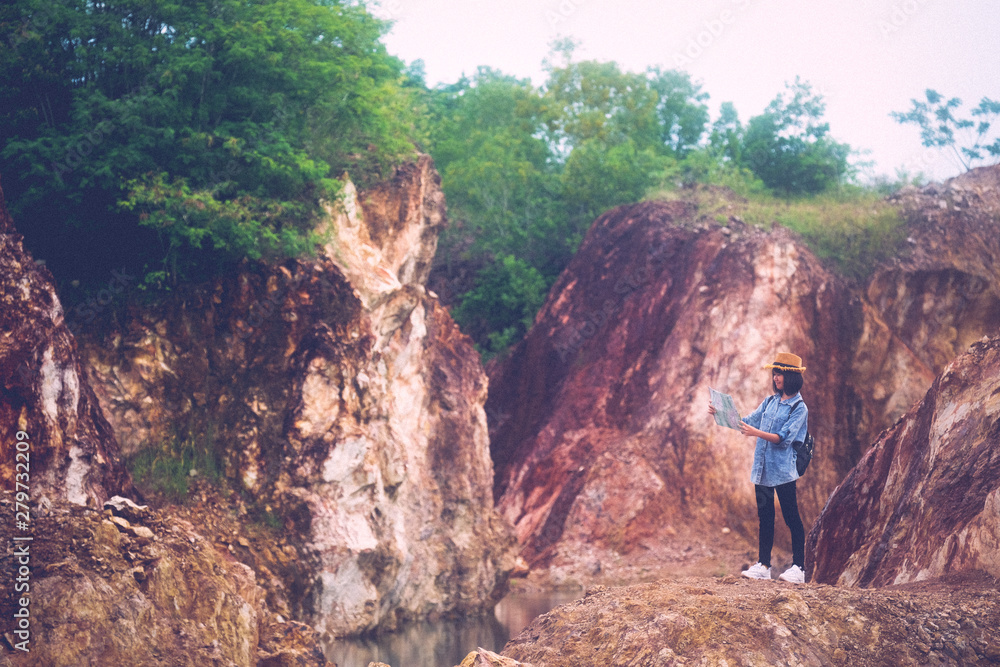 Solo travel in local asia, Teenager traveler holding map while hiking on mountain, Solo tourist traveller with map standing on top of stone hill background, Summer happy travel vacation in local asia Solo travel in local asia, Teenager traveler holding map while hiking on mountain, Solo tourist traveller with map standing on top of stone hill background, Summer happy travel vacation in local asia