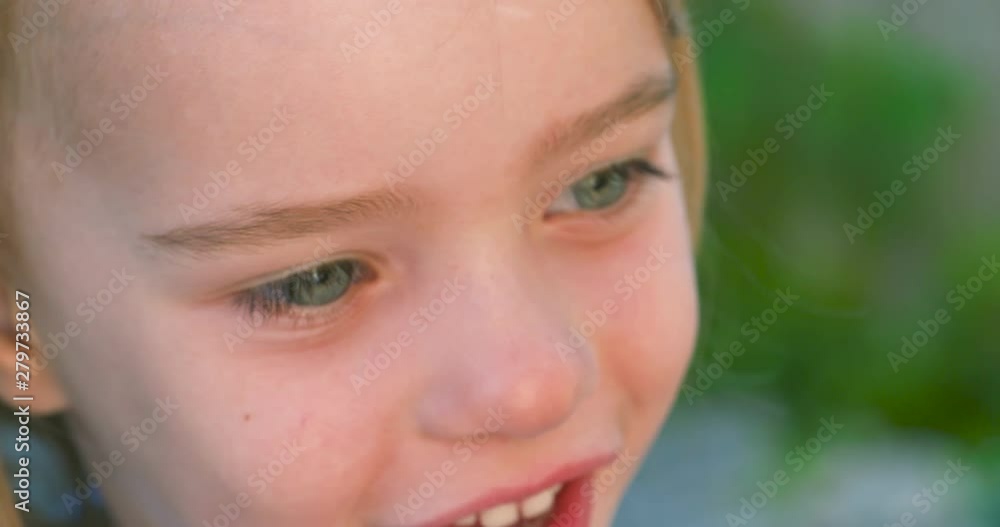 Beautiful slow motion portrait of a smiling, blue-eyed little girl Beautiful slow motion portrait of a smiling, blue-eyed little girl