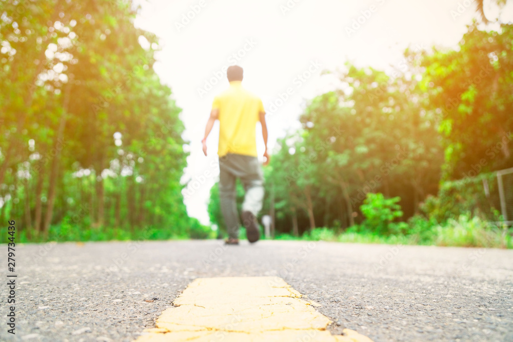 at countryside road and young man walking alone on the road . at countryside road and young man walking alone on the road .