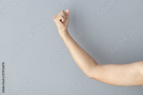 woman hand with clenched fist on grey background, health care and medical concept