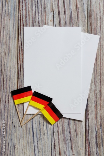 October 3, happy Day of German unity. the concept of patriotism , freedom and independence. Mini flags with a white card on wooden background