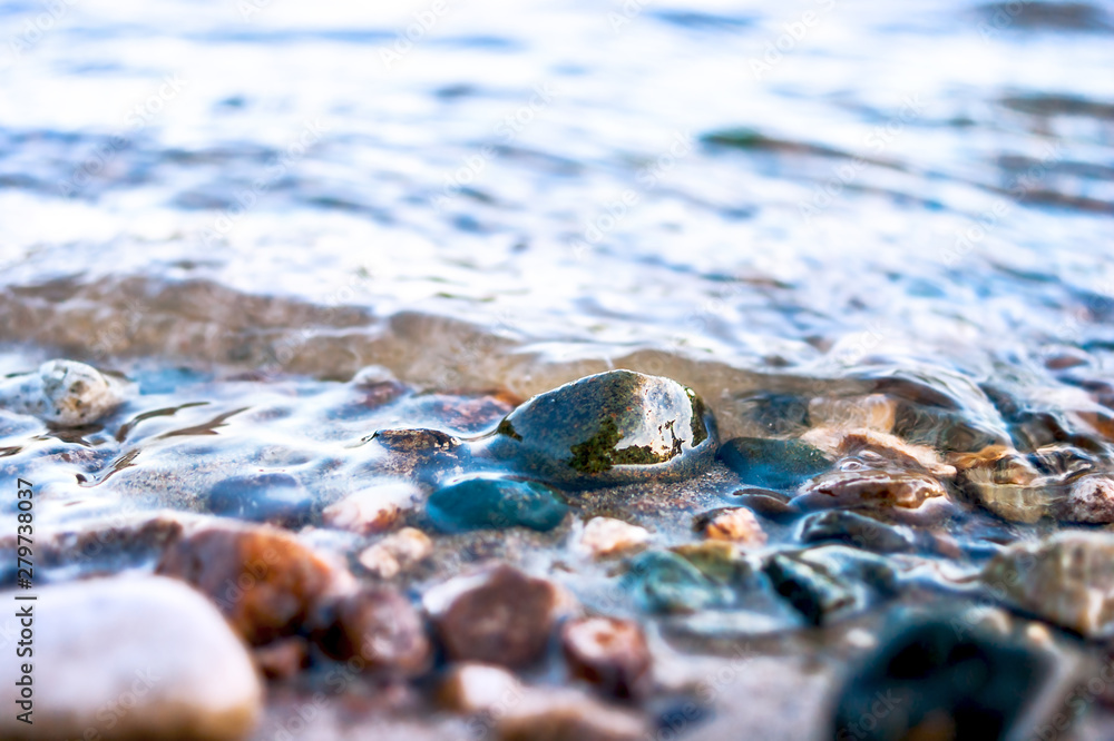Close-up View of Colorful Pebbles in Water Waves. Travel Concept. Close-up View of Colorful Pebbles in Water Waves. Travel Concept.