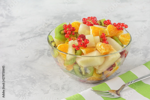 Fresh Snack Peeled Assorted Fruit Berry Salad Bowl. Low Calorie Healthy Breakfast Dish on Concrete Table. Ready to Eat Lunch. Ripe Orange, Kiwi Chopped Apple and Currant Cup Closeup