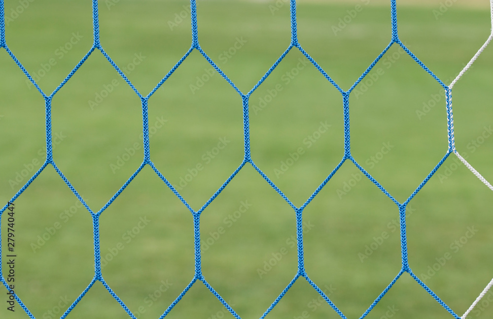 Soccer or football net background. Football net close up on blurred green grass football field Soccer or football net background. Football net close up on blurred green grass football field