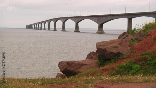 A wide shot of the Confederation Bridge from PEI, Canada featuring the red clay earth from the province.
