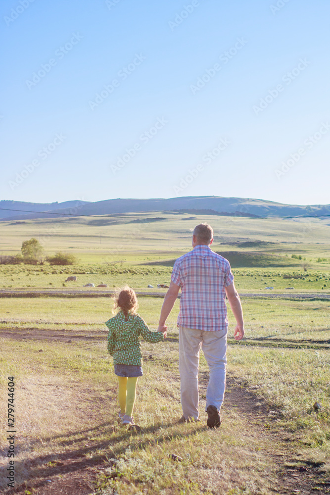 Happy dad walks with his daughter in the summer park