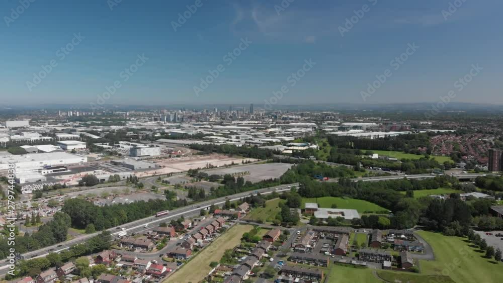 A shot panning left looking out over the motorway, Trafford Park and Manchester on a Summer day. You can see many of the houses in the area with Manchester skyline in the background. A shot panning left looking out over the motorway, Trafford Park and Manchester on a Summer day. You can see many of the houses in the area with Manchester skyline in the background.