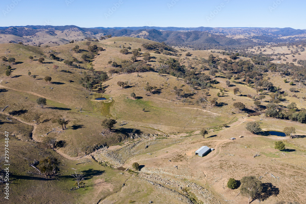 A dry creek bed running through hills in rural Australia. A dry creek bed running through hills in rural Australia.