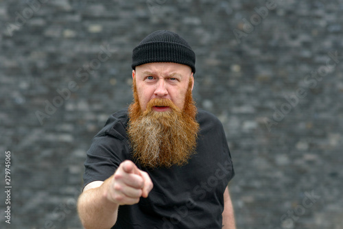 Bild auf Leinwand Bearded man pointing at the camera in disbelief