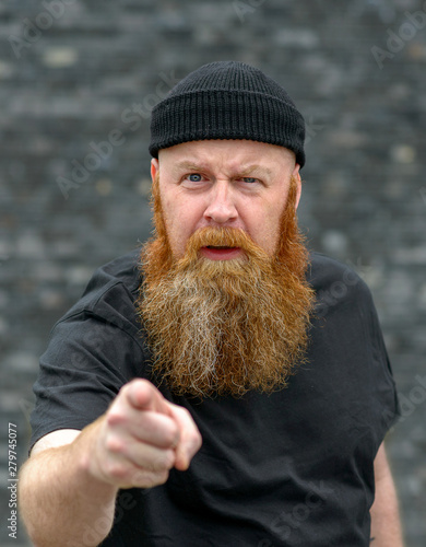 Bild auf Leinwand Bearded man pointing at the camera in disbelief