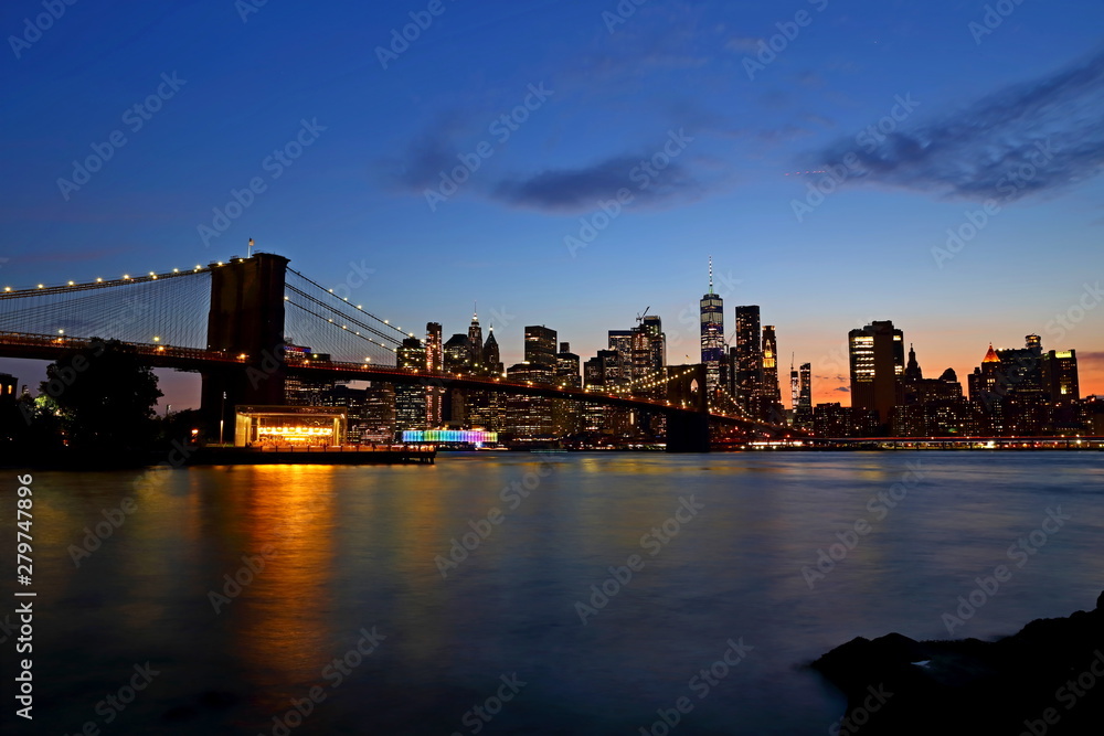 New York City downtown skyline and Brooklyn bridge at sunset