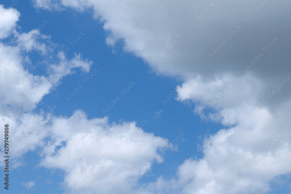 Blue sky texture background with white fluffy clouds. Abstract, cropped shot, horizontal. Nature's concept