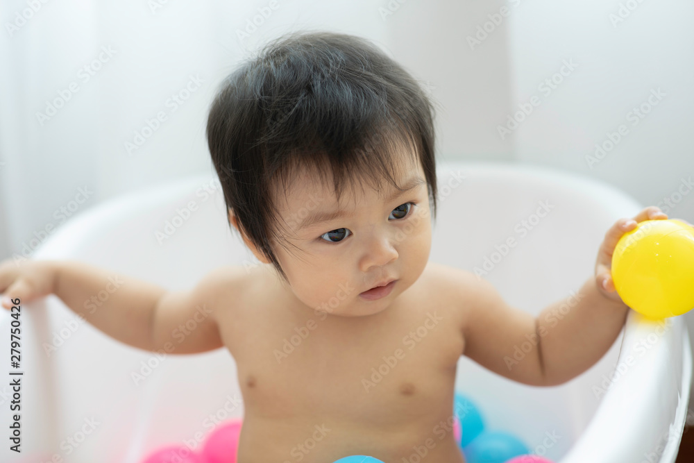 Cute Sweet Adorable Asian Baby Sitting on bathtub with plastic balls smiling and playing with happiness emotional in cozy bedroom,Healthy Baby Concept Cute Sweet Adorable Asian Baby Sitting on bathtub with plastic balls smiling and playing with happiness emotional in cozy bedroom,Healthy Baby Concept