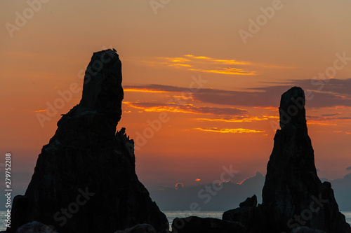 人のような形をした岩と日の出