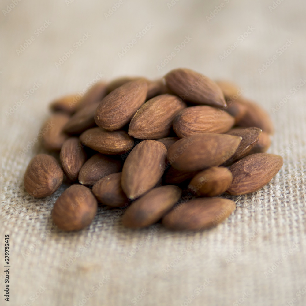 Pile of almonds on beige fabric Pile of almonds on beige fabric