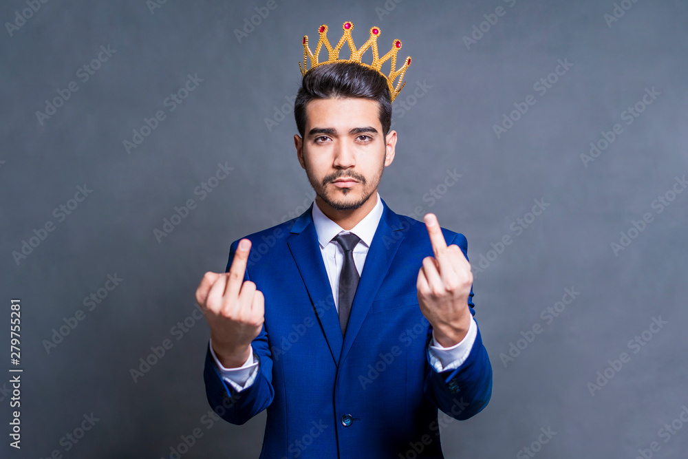 A man in a blue suit with a crown on his head shows middle fingers. A man in a blue suit with a crown on his head shows middle fingers.