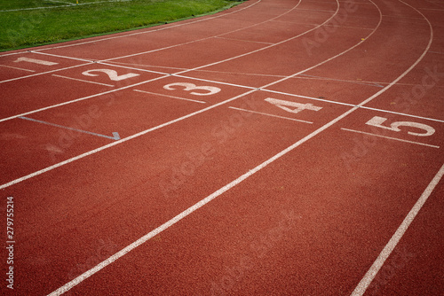 Sport. A red treadmill or athletics track with numner of line at the stadium. Copy space © vitleo