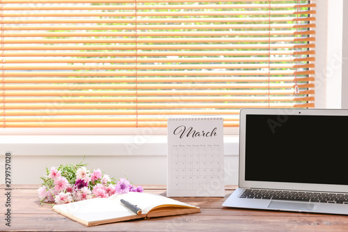 Calendar with laptop, flowe...