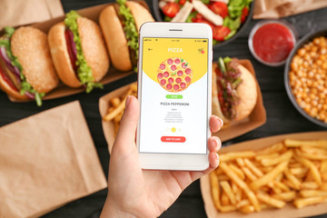 Woman with mobile phone ordering food online