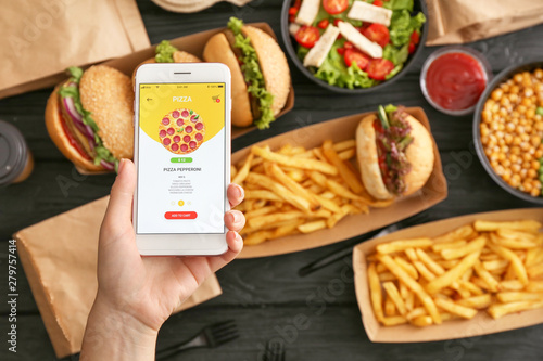Foto Woman with mobile phone ordering food online