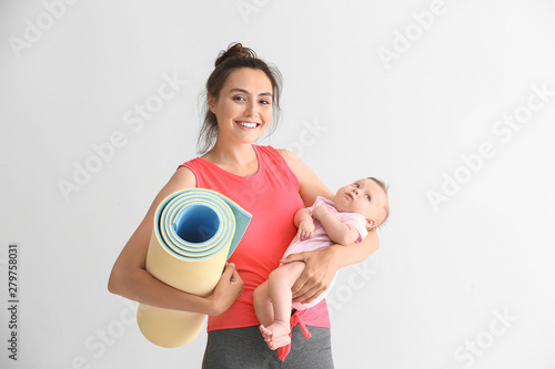 Mother with yoga mat and cu...
