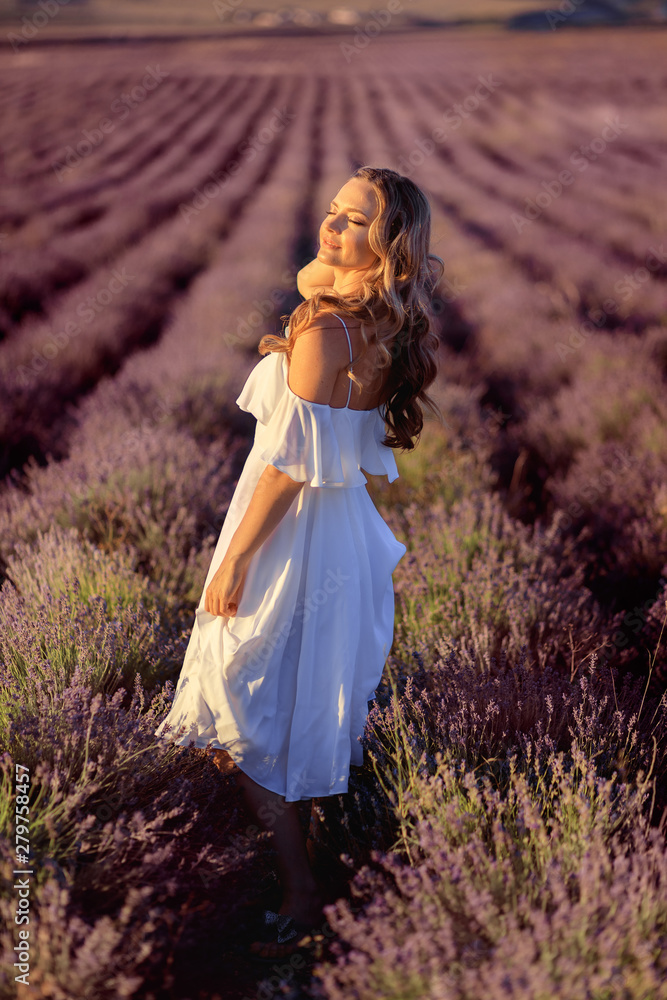 Beautiful girl on the lavender field. Beautiful woman in the lavender field on sunset.