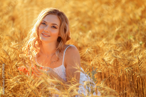 Beautiful young woman in wheat field at sunset outdoor . © Fototocam